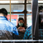 Mujer con tapabocas en bus (coronavirus)