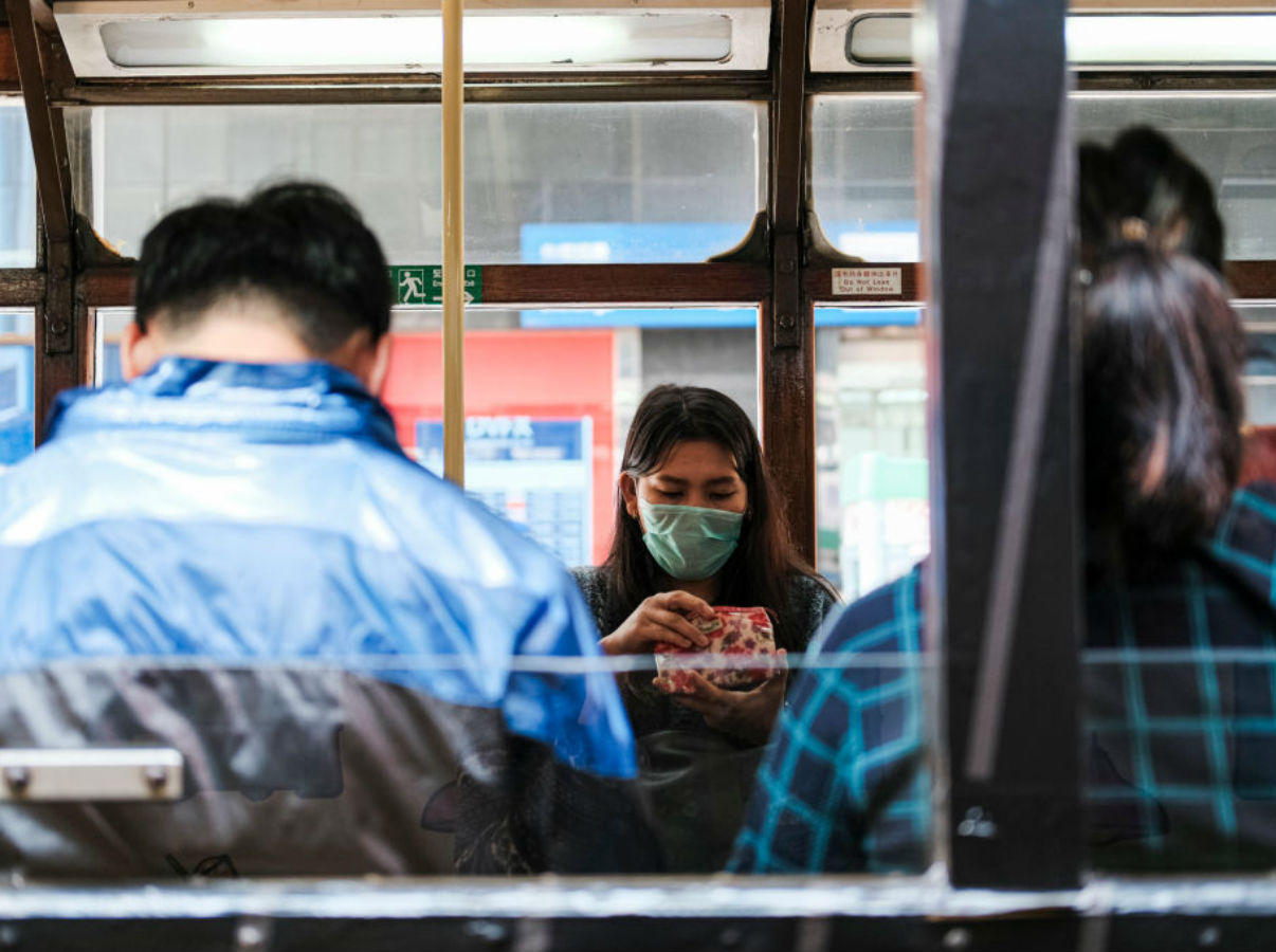 Mujer con tapabocas en bus (coronavirus)