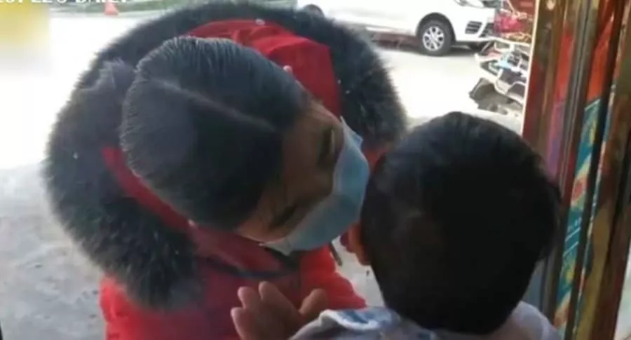 Enfermera da beso a hijo a través de vidrio