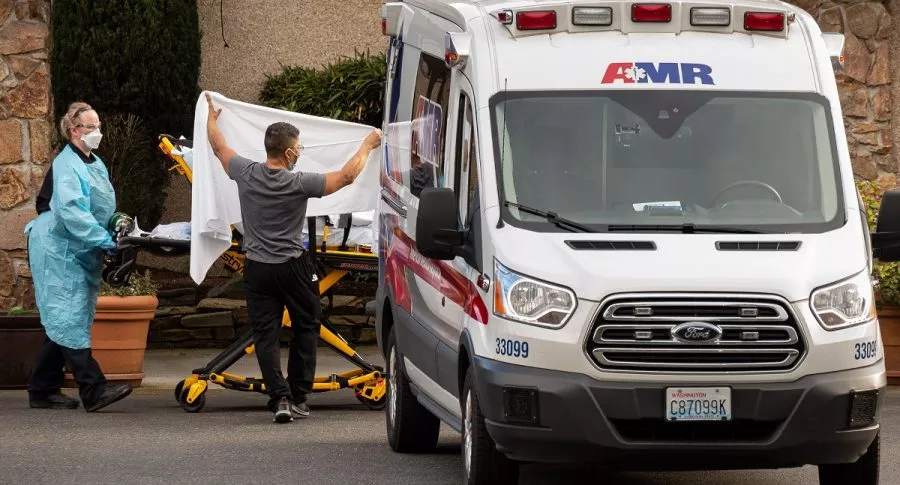 Trabajadores de la salud transportan a un paciente de covid-19 en Kirkland, Washington.