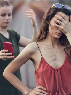 Mujer mostrando el celular a otra