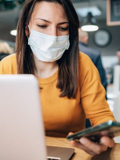 Mujer con tapabocas mirando un celular
