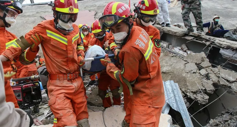 Rescatistas socorren a afectados por derrumbe de hotel Xinjia en China.
