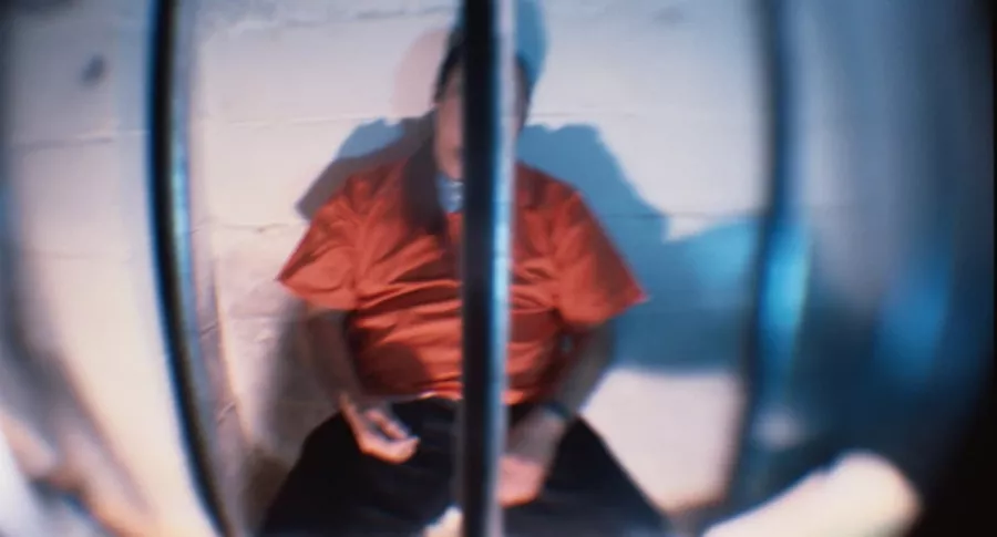 Hombre sentado en celda de prisión.