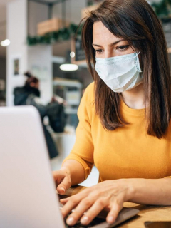 Imagen de referencia de mujer con tapabocas en un computador
