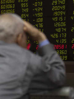 Hombre frente a tablero de valores de bolsa