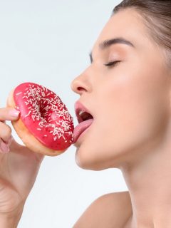 Mujer lamiendo una dona