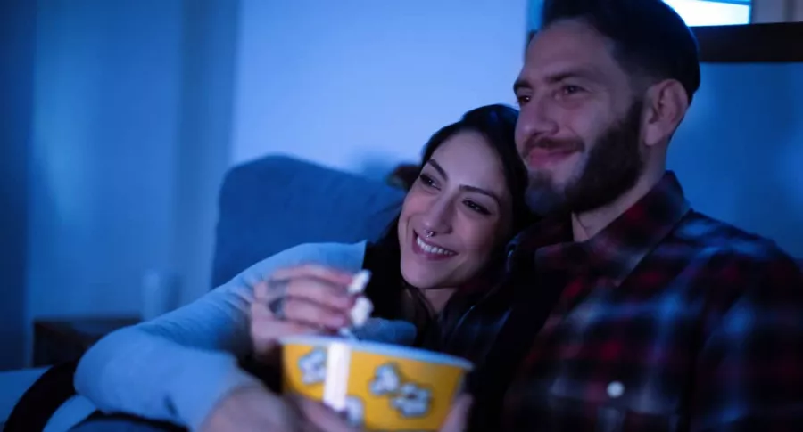 Hombre y mujer viendo televisión, cine
