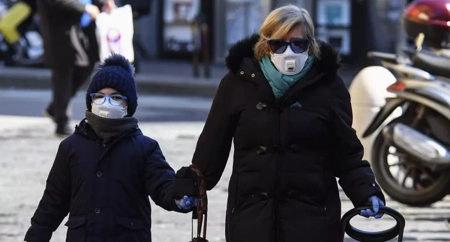 Mujer y una niña caminando por la calles de Roma en medio de la pandemia del COVID-19, que podría empeorar en Europa, según la OMS.