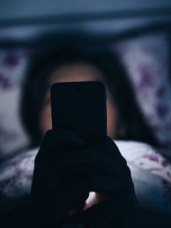 Joven acostada con celular