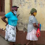 Mujeres protegidas con tapabocas caminan por una calle de Quibdó