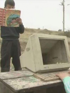 Niños jugando con computador dañado.