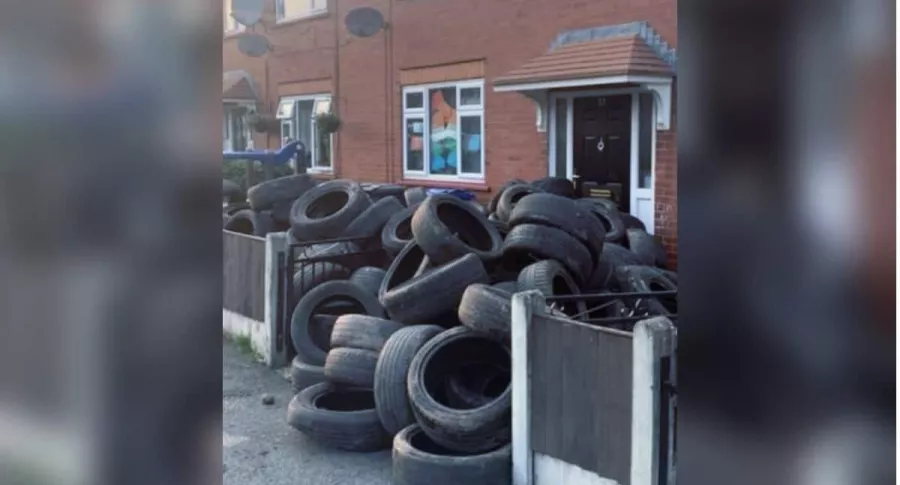 Hombre bloqueó la puerta de su vecino con decenas de neumáticos, como venganza.