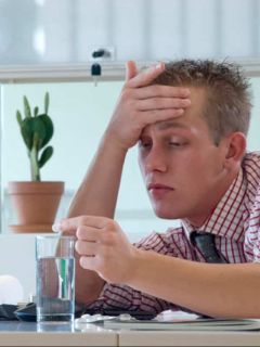Hombre con resaca en oficina