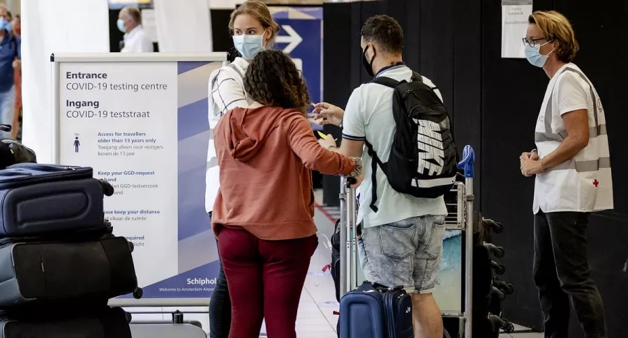 Pasajeros que hacen cola en el aeropuerto de Schiphol, cerca de Ámsterdam, ilustran artículo sobre inminente migración de jóvenes de Colombia al exterior por crisis.