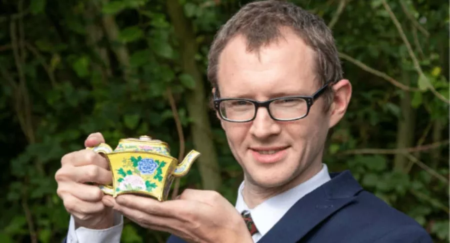 Foto de británico sosteniendo una 'tetera' china que un hombre encontró en su casa y que ahora le representará una millonada.