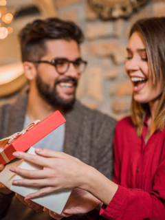 Mujer abre regalo que le dio su pareja, a propósito del día de amor y amistad, y los regalos que se pueden obsequiar en esa fecha