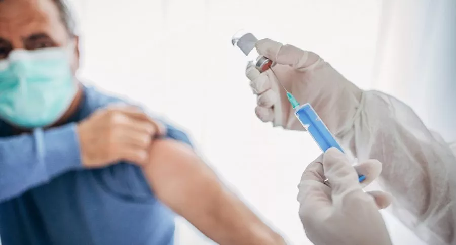 Médico aplicando vacuna contra COVID-19: Invima autorizó reclutar para pruebas de vacuna colombiana.