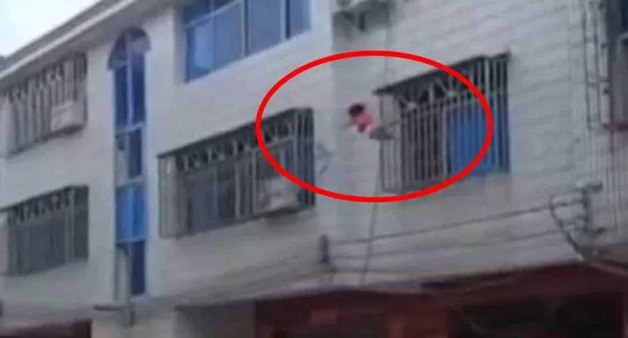 Captura de pantalla de niña cayendo desde un tercer piso, en China