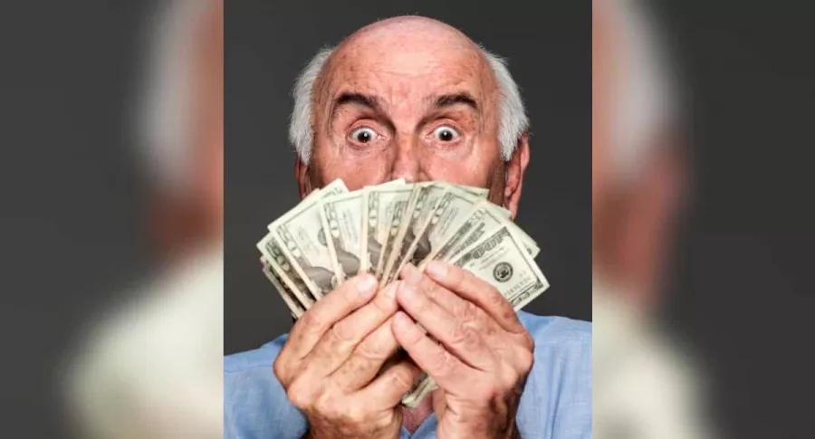 Imagen de hombre sosteniendo cientos de dólares ilustra nota de estadounidense que ganó la lotería.