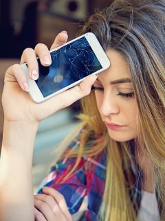 Imagen de mujer preocupada porque su celular se dañó para ilustrar nota sobre los elementos aparentemente inofensivos que pueden dañar el móvil