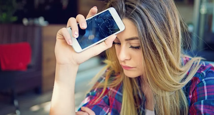 Imagen de mujer preocupada porque su celular se dañó para ilustrar nota sobre los elementos aparentemente inofensivos que pueden dañar el móvil