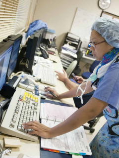 Profesional de la salud revisa exámenes médicos en computadores de un hospital, sitio que fue víctima de un ataque cibernético en Alemania, lo que causó que una mujer no pudiera ser atendida y falleciera