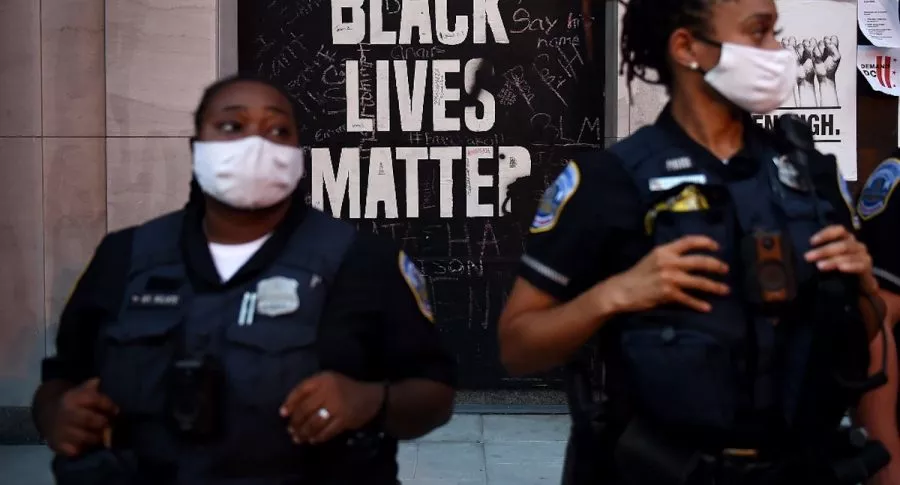 Letrero de Black Lives Matter detrás de policías de Nueva York.