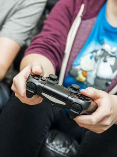 Dos personas con controles de consolas de videojuegos, los cuales, según una investigación, mejoran la memoria al ser adultos si se juegan en la infancia
