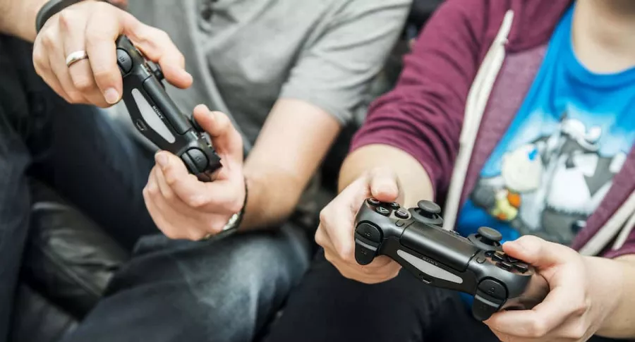 Dos personas con controles de consolas de videojuegos, los cuales, según una investigación, mejoran la memoria al ser adultos si se juegan en la infancia