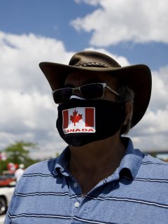 Imagen de hombre usando tapabocas con la bandera de Canadá ilustra nota sobre advertencia de rebrote de coronavirus en ese país