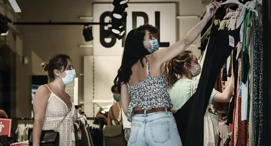 Imagen con clientas que miran ropa en tienda durante las rebajas en Burdeos, Francia, en julio de 2020, ilustra artículo sobre tercer Día sin IVA en Colombia.