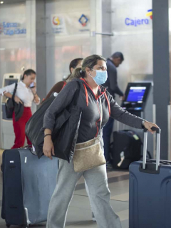 Imagen de viajera usando tapabocas en aeropuerto para ilustrar nota sobre las medidas de bioseguridad antes, durante y después de un vuelo