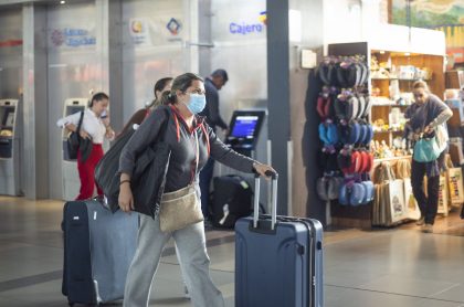 Imagen de viajera usando tapabocas en aeropuerto para ilustrar nota sobre las medidas de bioseguridad antes, durante y después de un vuelo