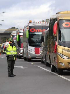 Imagen de policía y buses intermunicipales para ilustrar nota sobre los protocolos de seguridad vial para viajar en la semana de receso
