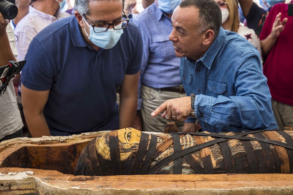 El ministro egipcio de Turismo y Antigüedades Khaled Al-Anani (derecha), y Mustafa Waziri (izquierda), Secretario General del Consejo Supremo de Antigüedades, develan una de las momias dentro de un sarcófago descubierto por la misión arqueológica egipcia.