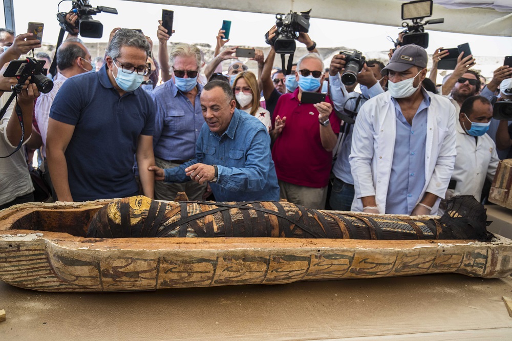El ministro egipcio de Turismo y Antigüedades Khaled Al-Anani (derecha), y Mustafa Waziri (izquierda), Secretario General del Consejo Supremo de Antigüedades, develan una de las momias dentro de un sarcófago descubierto por la misión arqueológica egipcia.