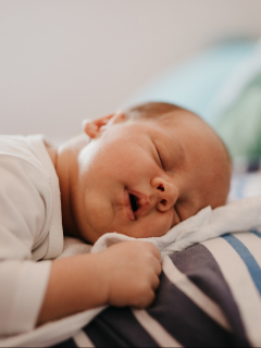 Foto de bebé durmiendo con su papá, a propósito de los nombres de niño y niña que significan luz y esperanza