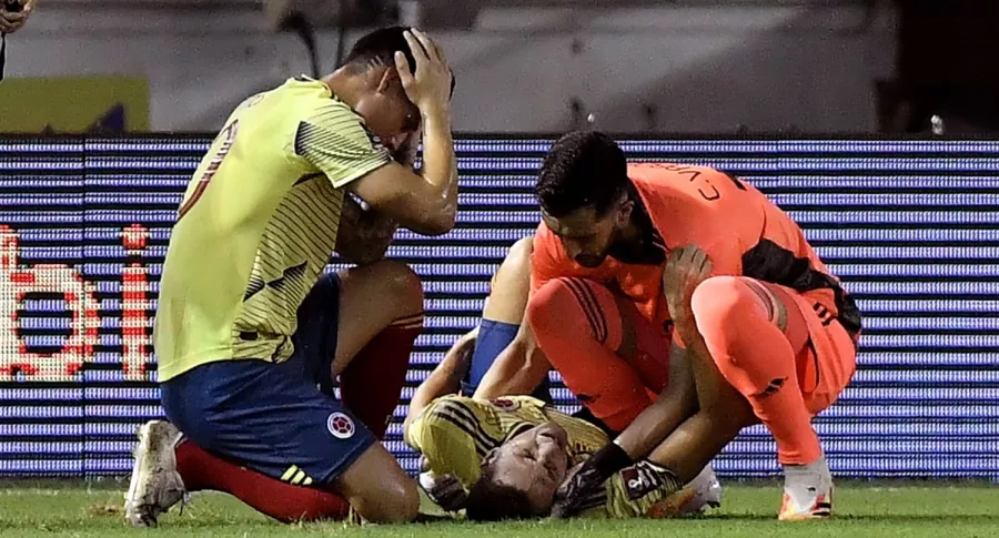 James Rodríguez y Camilo Vargas consuelan a Santiago Arias apenas sufrió una fuerte lesión en el partido contra Venezuela.