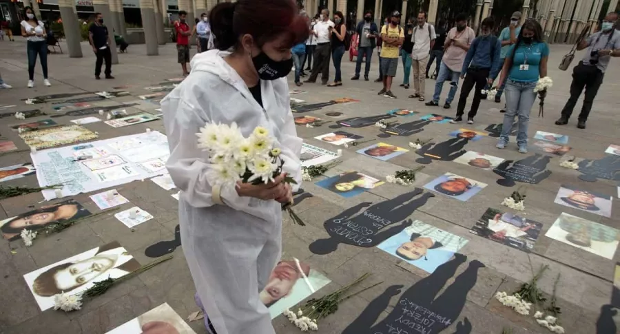 Una mujer asiste a un acto de homenaje por las víctimas durante la pandemia de COVID-19.