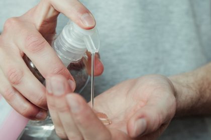 Hombre usando desinfectante de manos, a propósito de estudio que revela que el coronavirus puede sobrevivir 9 horas en la piel.