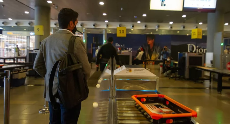 Viajero pasando por el control de seguridad en el aeropuerto El Dorado, que dio unas recomendaciones para vuelos internacionales desde Colombia