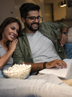Pareja viendo una película en un computador para ilustrar nota sobre mejores sitios de Internet para ver película y series gratis