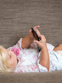 Niña pequeña mirando el celular.