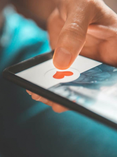 Persona presionando el ícono de un corazón en aplicación de citas para ilustrar nota sobre cómo funciona Facebook Dating, la competencia de Tinder