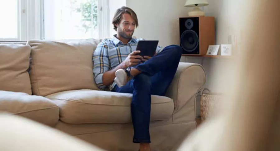 Hombre mira tableta, ilustra nota de empresa que pagará millonada por navegar en Internet