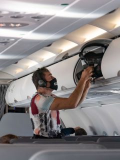 Pasajero de avión usando tapabocas para ilustrar nota sobre estudio que dice que viajar en avión es más seguro que salir a comer