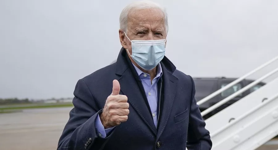 El demócrata Joe Biden, por quien se depositaron los primeros 5 votos en urnas en EE.UU. en las elecciones presidenciales, habla con periodistas antes de abordar su avión en el aeropuerto de New Castle, el 30 de octubre de 2020.
