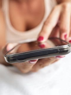 Mujer en la cama usando el celular para ilustrar nota sobre qué es sexting y casos polémicos