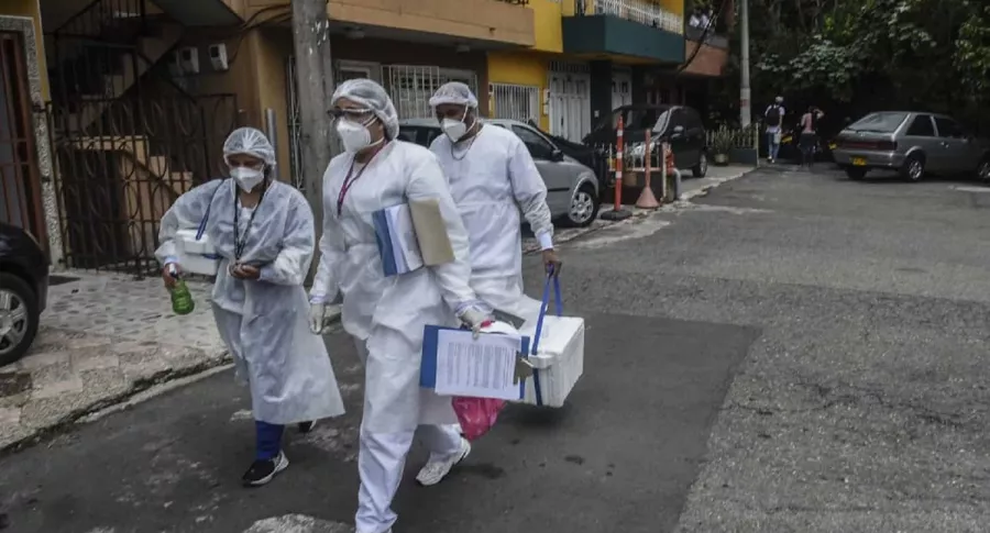 Trabajadores de la salud fotografiados mientras transportan muestras de sangre durante un estudio de prueba de COVID-19 en Medellín, Colombia. 